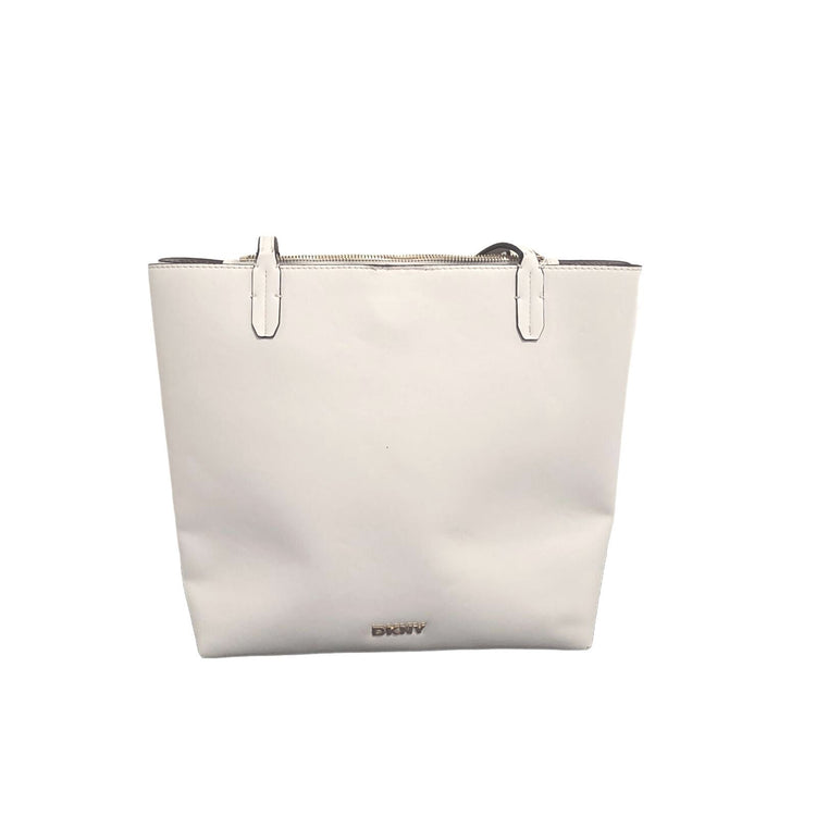 A white leather tote bag with silver-tone metal hardware and a small gold-tone DKNY logo at the bottom center, shown against a plain white background.